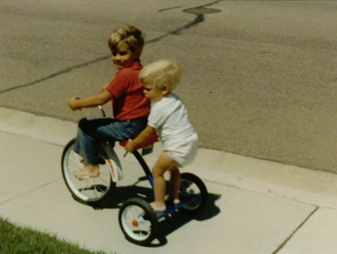 Brad Lovell and his brother playing on a tricycle when they were kids.
